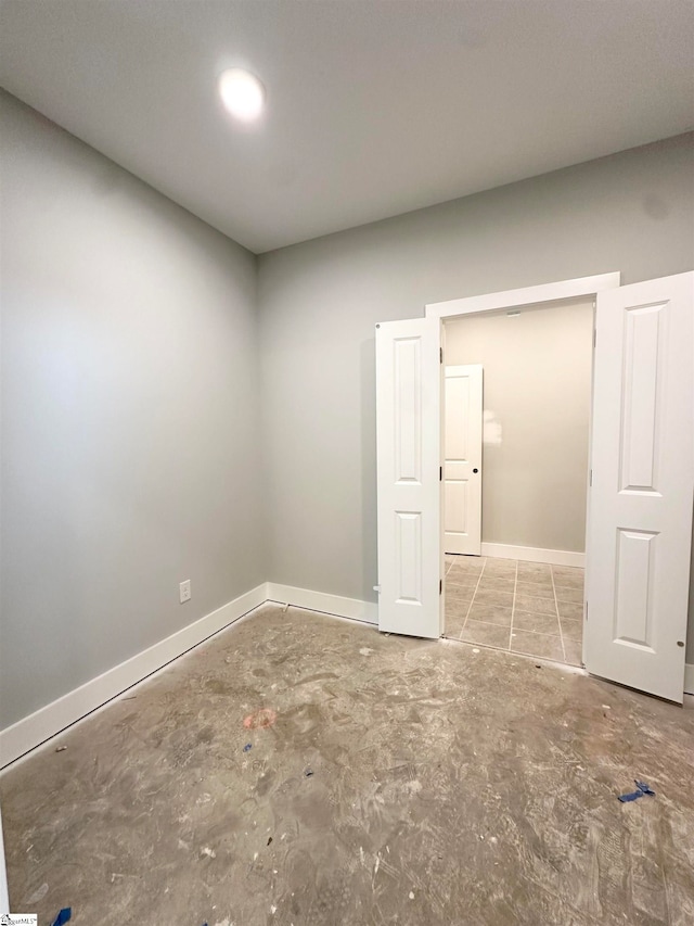 empty room with baseboards and concrete floors