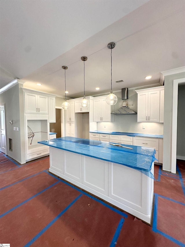 kitchen featuring recessed lighting, white cabinets, hanging light fixtures, and wall chimney range hood