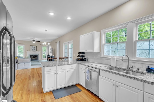 kitchen featuring ceiling fan, light hardwood / wood-style flooring, tasteful backsplash, sink, and appliances with stainless steel finishes