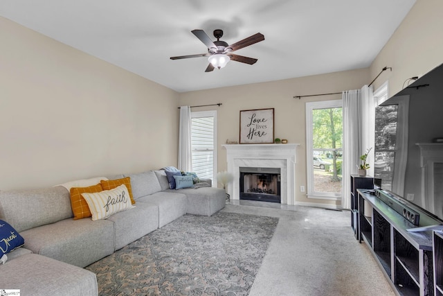 living room featuring a high end fireplace and ceiling fan