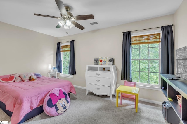 carpeted bedroom featuring ceiling fan and multiple windows