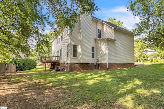 rear view of house with central AC, a wooden deck, and a yard