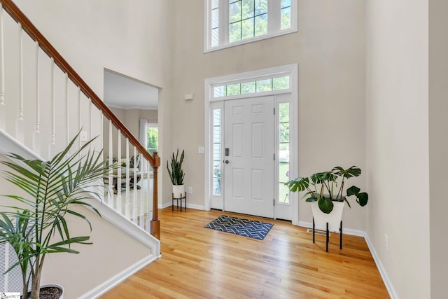 entrance foyer with a towering ceiling and light wood-type flooring