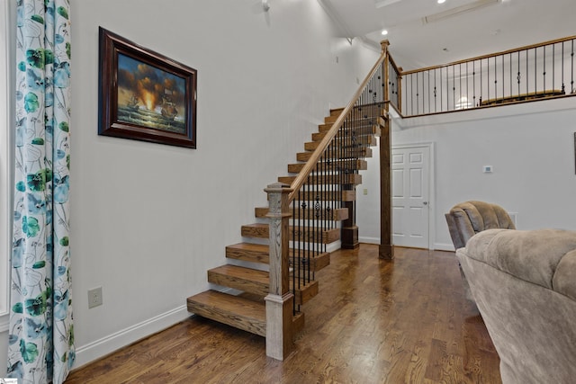 stairs featuring a high ceiling and dark wood-type flooring