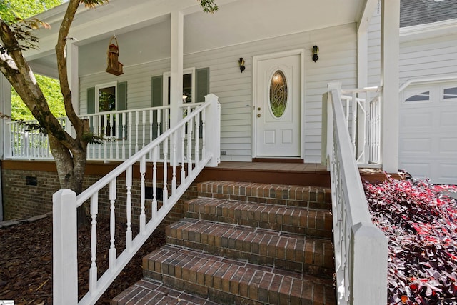 doorway to property featuring covered porch and a garage