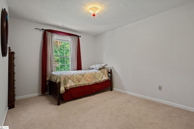 bedroom featuring a textured ceiling and carpet floors