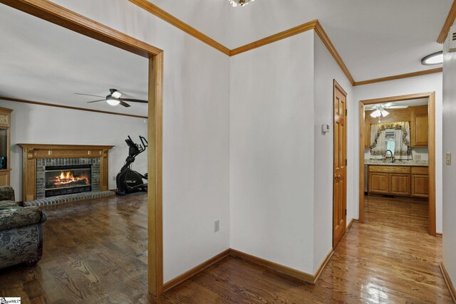 hall featuring sink, hardwood / wood-style flooring, and crown molding