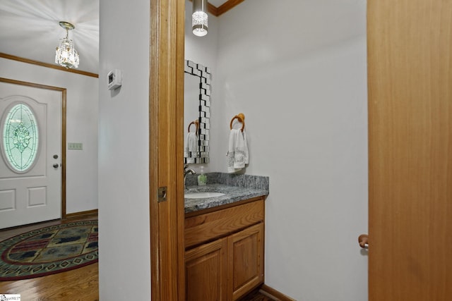 bathroom with crown molding, large vanity, and hardwood / wood-style floors