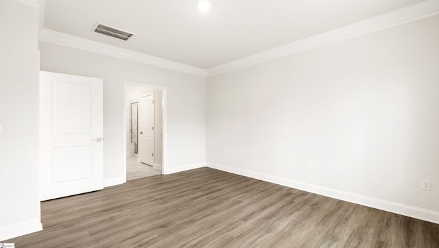 unfurnished room featuring ornamental molding and wood-type flooring