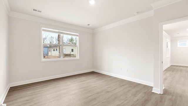 empty room with crown molding and light hardwood / wood-style flooring