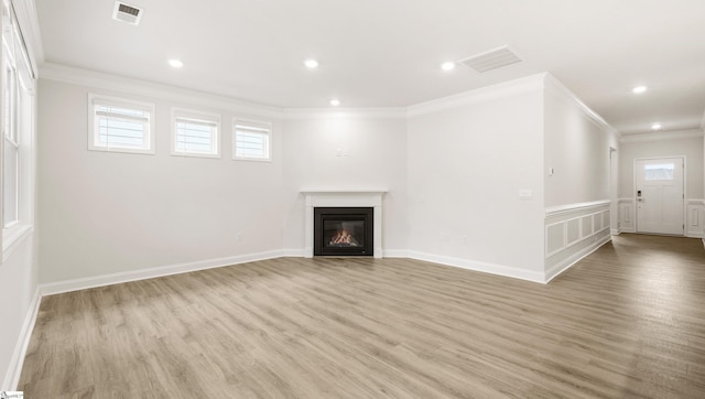 unfurnished living room with crown molding and light hardwood / wood-style flooring