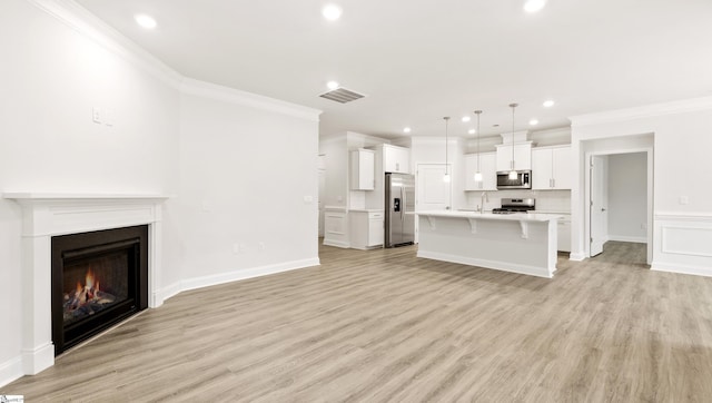 unfurnished living room featuring ornamental molding, sink, and light wood-type flooring