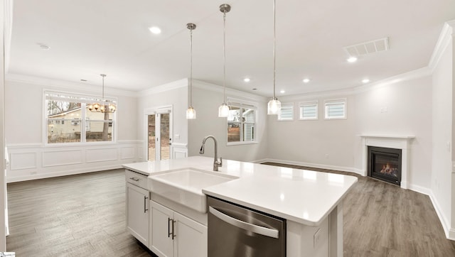 kitchen with sink, stainless steel dishwasher, an island with sink, pendant lighting, and white cabinets