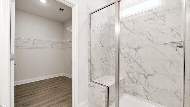 bathroom featuring a shower with door and wood-type flooring