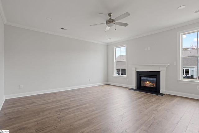 unfurnished living room featuring crown molding, hardwood / wood-style flooring, a wealth of natural light, and ceiling fan