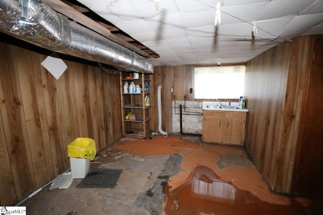 basement with wooden walls and a paneled ceiling