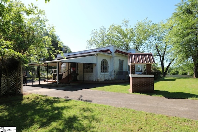 view of front of house with a front yard and a carport