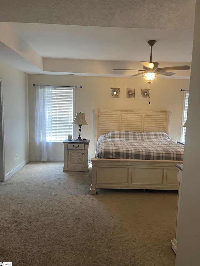 bedroom featuring ceiling fan, multiple windows, and carpet flooring