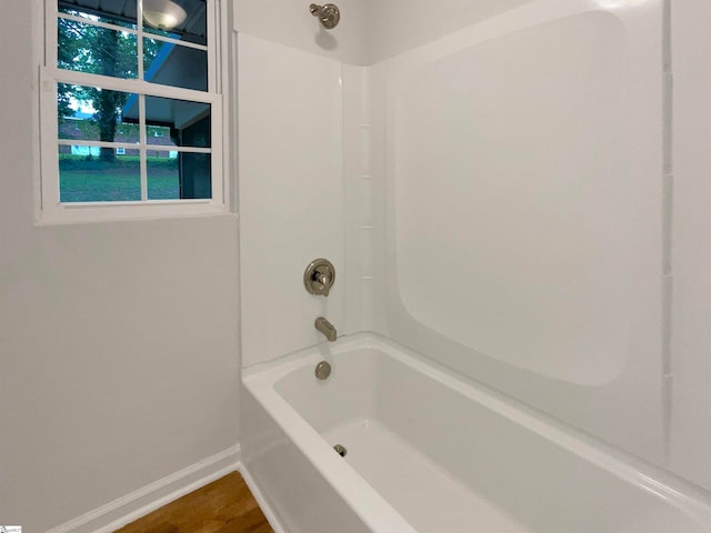 bathroom with tub / shower combination and wood-type flooring