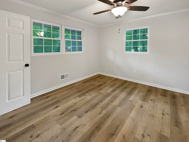 empty room featuring ceiling fan, crown molding, and hardwood / wood-style flooring