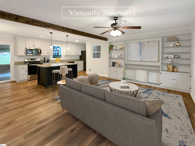 living room featuring beamed ceiling, ceiling fan, and light hardwood / wood-style floors