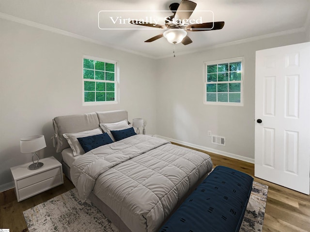 bedroom featuring dark hardwood / wood-style floors, ceiling fan, and ornamental molding