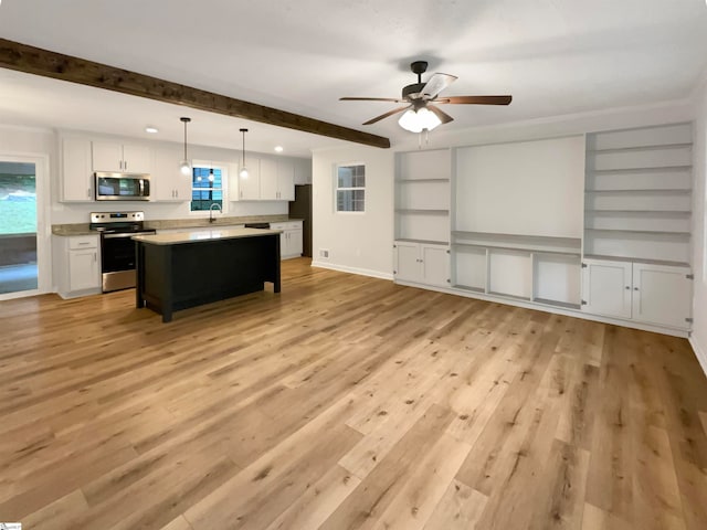 kitchen with a center island, white cabinetry, light wood-type flooring, stainless steel appliances, and decorative light fixtures