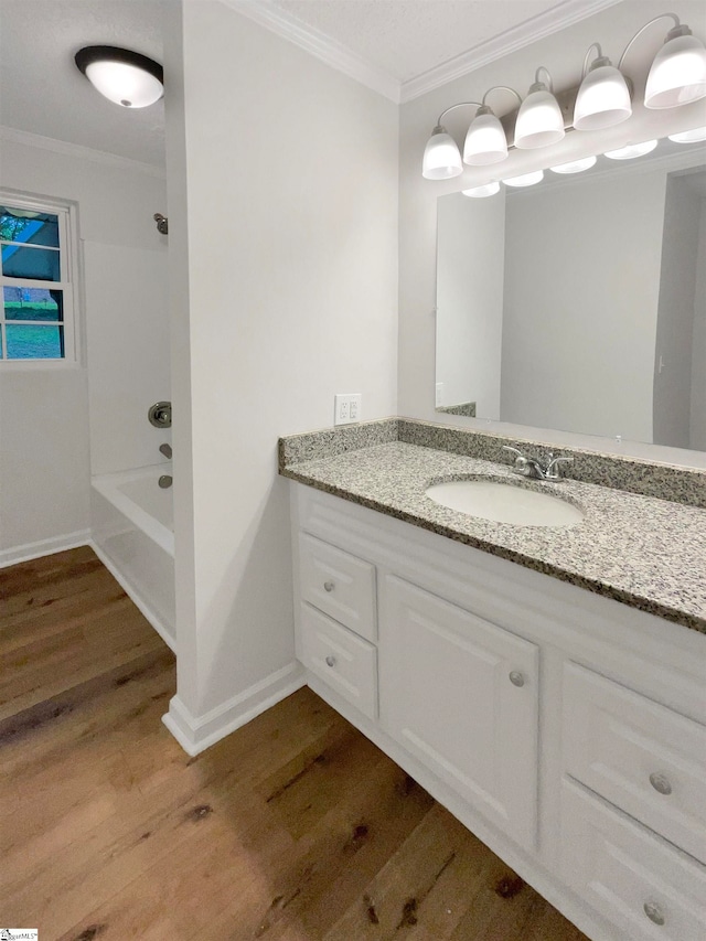 bathroom featuring shower / bathtub combination, crown molding, vanity, and hardwood / wood-style floors