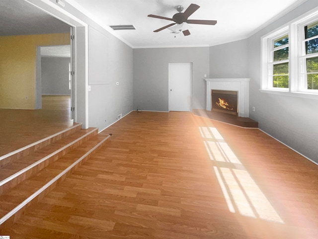 unfurnished living room featuring crown molding, ceiling fan, and hardwood / wood-style floors