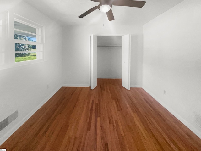 unfurnished bedroom featuring a closet, wood-type flooring, and ceiling fan