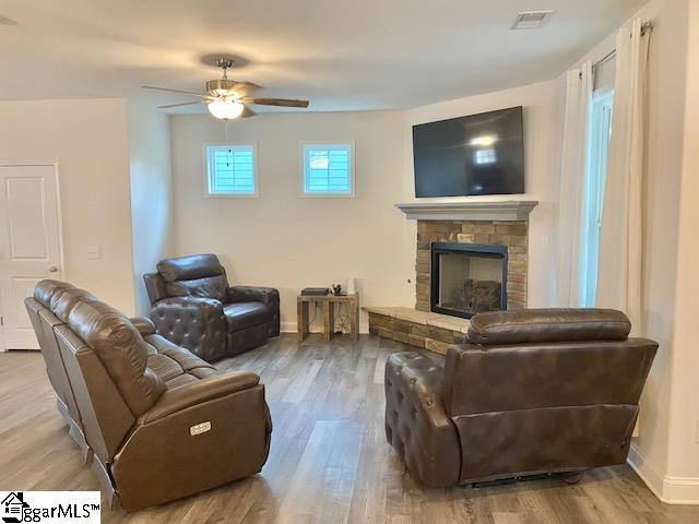 living room featuring hardwood / wood-style flooring, a fireplace, and ceiling fan