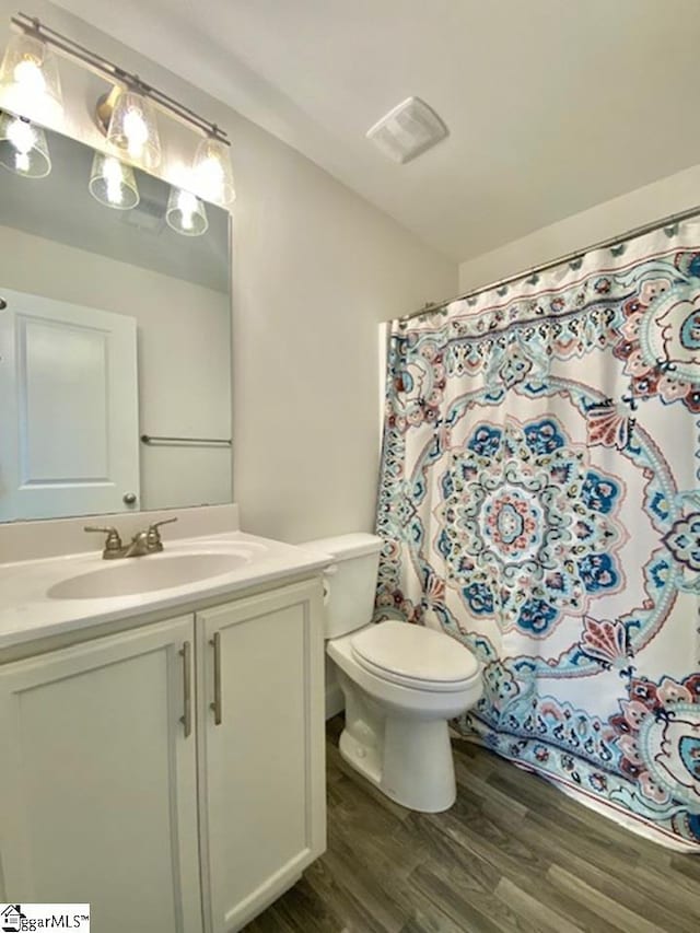 bathroom featuring hardwood / wood-style flooring, toilet, and large vanity