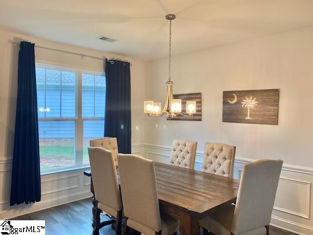 dining area with a chandelier and dark wood-type flooring