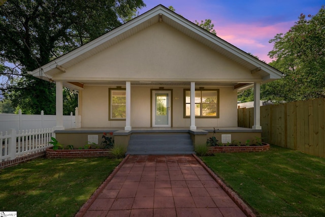 bungalow with a porch and a yard