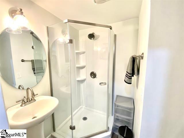 bathroom featuring sink and a shower with shower door