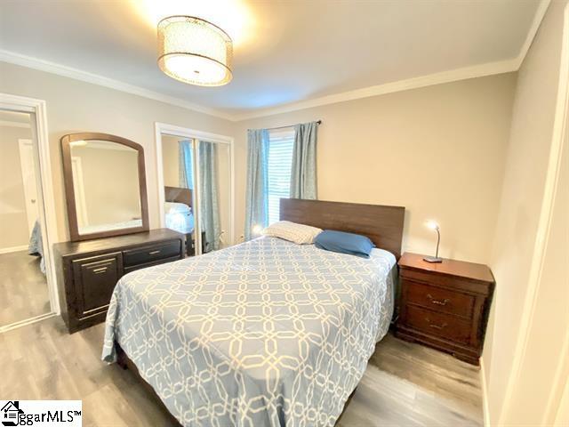 bedroom featuring crown molding and hardwood / wood-style flooring