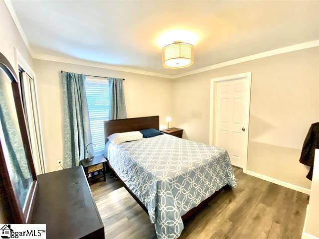 bedroom with crown molding and hardwood / wood-style floors