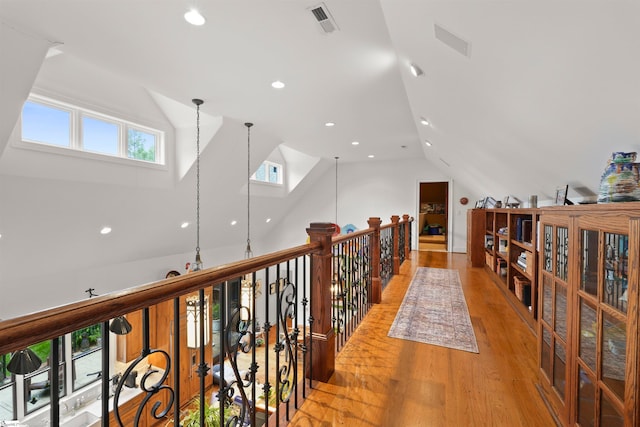 hallway featuring vaulted ceiling and light hardwood / wood-style flooring