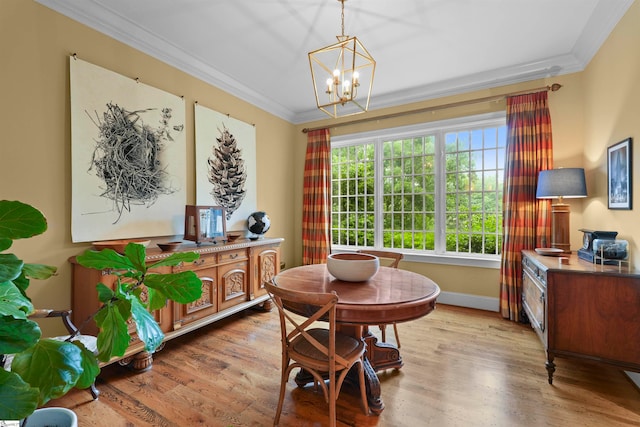 dining room with a chandelier, light wood-type flooring, and crown molding