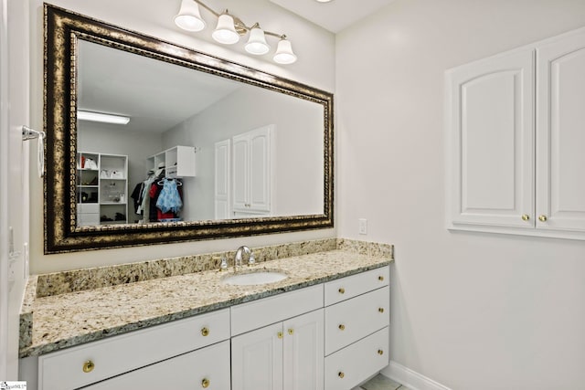 bathroom featuring a closet, vanity, and baseboards