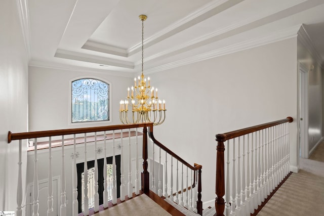 stairway featuring baseboards, a raised ceiling, ornamental molding, an inviting chandelier, and carpet