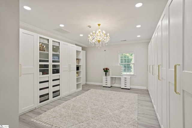 walk in closet featuring light wood-type flooring, visible vents, and a notable chandelier