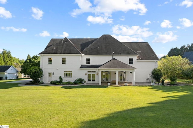 rear view of house featuring french doors, a patio area, and a lawn