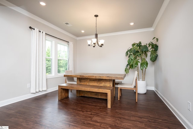 dining space featuring crown molding, dark wood-type flooring, and an inviting chandelier