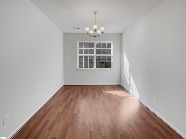 unfurnished dining area with a notable chandelier and wood-type flooring