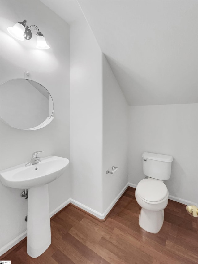 bathroom with sink, toilet, lofted ceiling, and hardwood / wood-style flooring