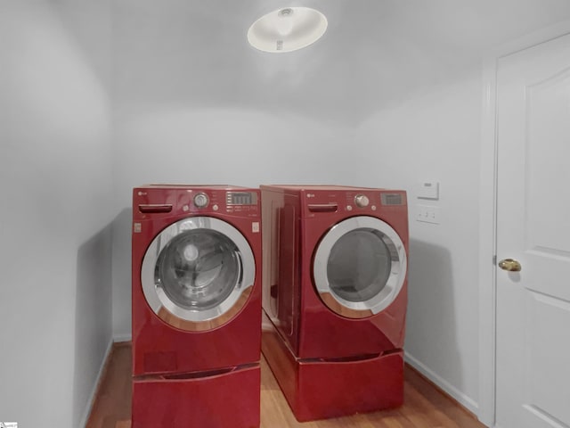 washroom with light hardwood / wood-style floors and independent washer and dryer