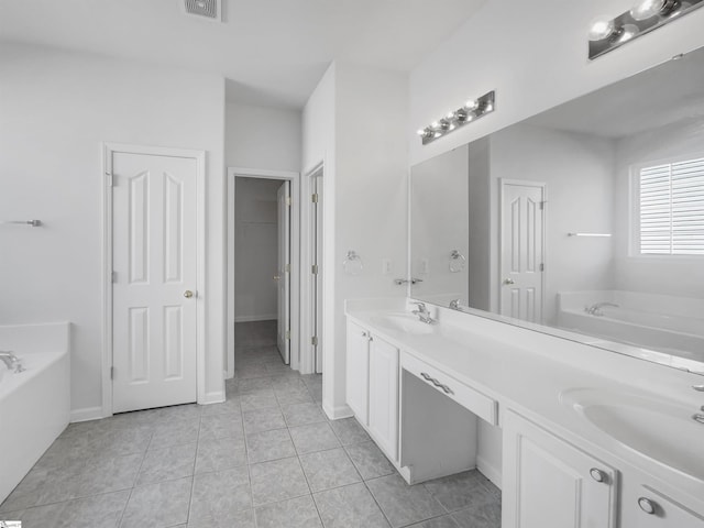 bathroom featuring vanity, a tub to relax in, and tile patterned floors