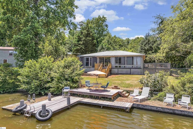 dock area featuring a deck with water view and a lawn