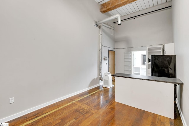 kitchen featuring beamed ceiling, dark hardwood / wood-style flooring, and white cabinets